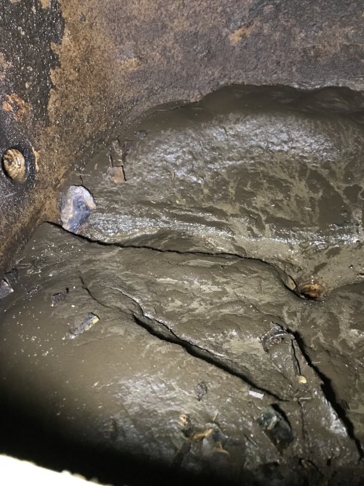 Inuti en smutsig hydrofor från 1945 med tydliga avlagringar och klegg längs väggarna.