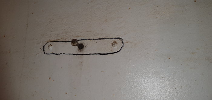 Vägg med utmarkerat och borttaget område där spjället till en vedspis har suttit, visande en renoveringsprocess.