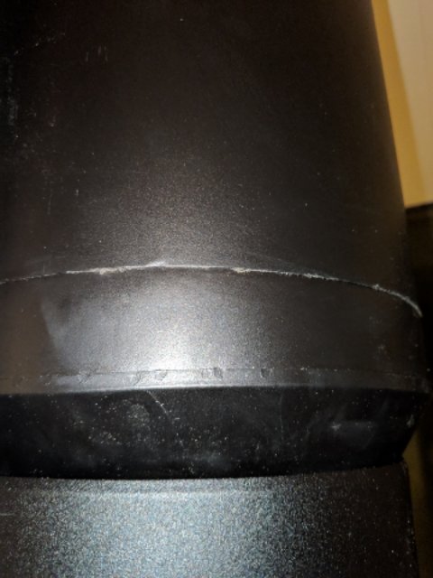 Närbild på en felaktigt monterad skorsten med synliga repor och dålig tätningsfog, vilket lett till läckage.