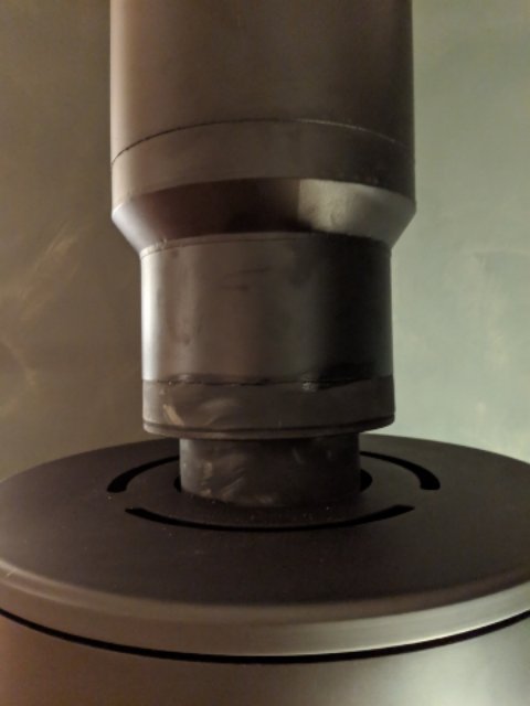 Felaktigt installerad skorstensanslutning med synliga tillämpningsproblem och otätheter på en kamin.