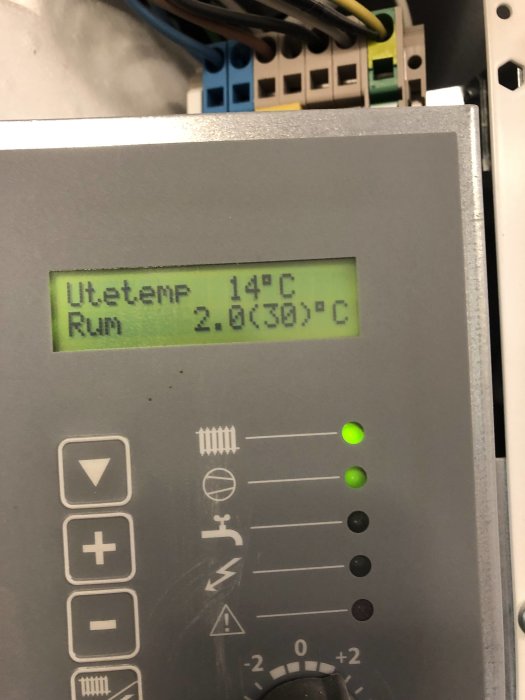 Närbild av Nibe värmepumpsdisplay visande utetemperatur 14°C och rumstemperatur.