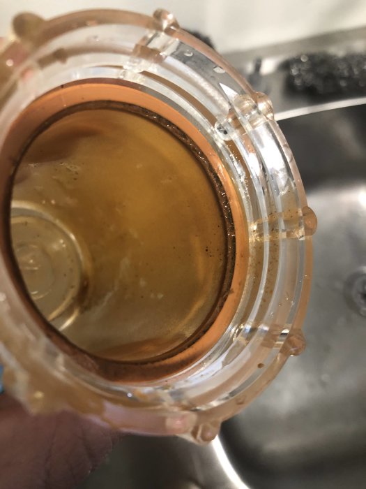Brun beläggning i genomskinlig sandfilterburk som tyder på förekomst av järn i vatten.