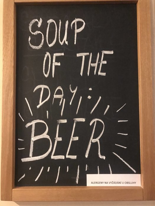 Svart tavla med texten "SOUP OF THE DAY: BEER" skrivet med krita, inuti en träram.