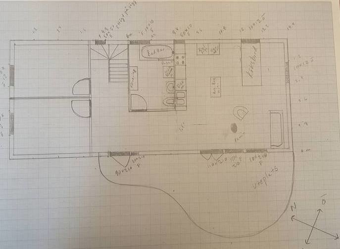 Handritad planritning av ett fritidshus med markerade allmänna utrymmen och sovrum.