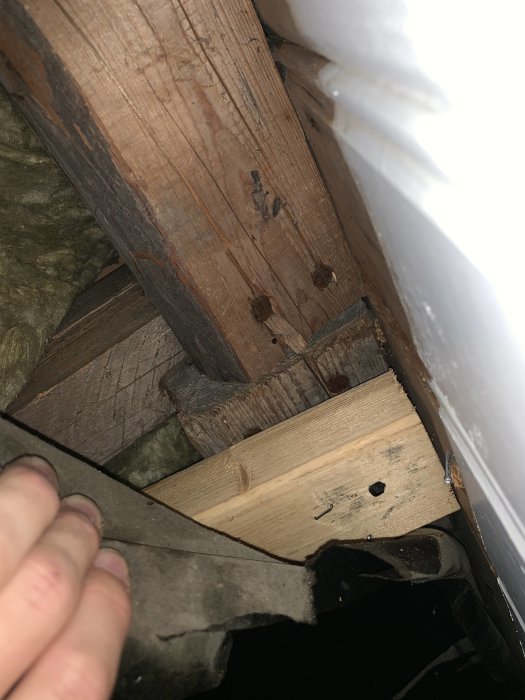 Bild av takbjälkar med mörka små bjälkar upptill, eventuellt ej bärande och inte fästa vid sidorna.