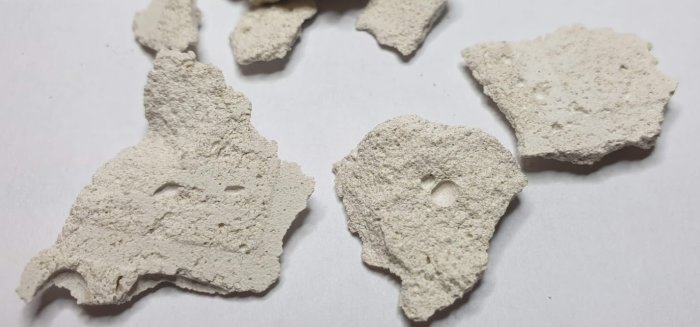 Bitar av ett smuligt vitt material som liknar lättbetong, bortbrutet från ett underlag.
