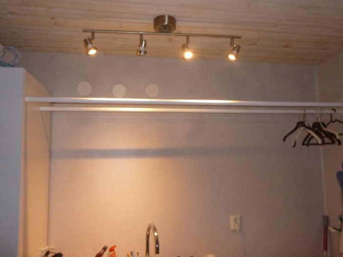 Två långa stålrör monterade horisontellt för torkning av tvätt i rum med trätak och belysning.