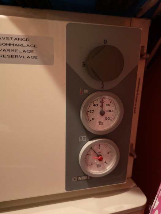 Värmepumpstermostat på 20 grader med etikett för inställningslägen överst.