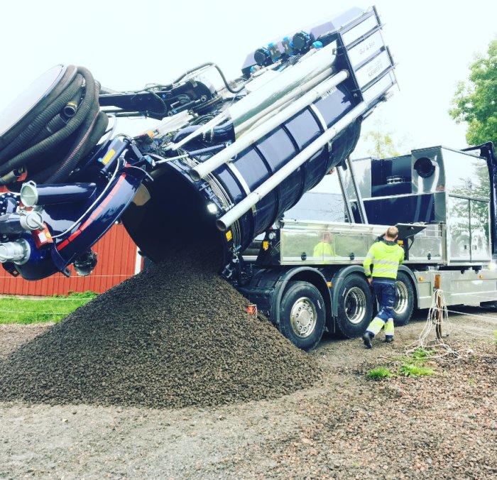 Lastbil som tömmer grus för tunnelbyggande under fastighet.