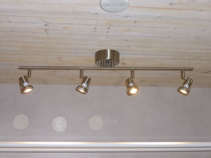 Takmonterad ljusramp med fem riktbara spotlights i ett kök, ovanför en diskbänk.