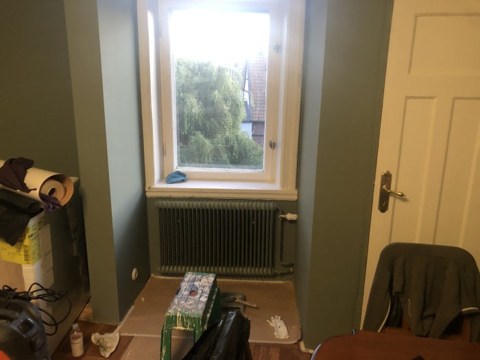 Element målat i samma gröna nyans som väggen i en studentlägenhet under renovering.