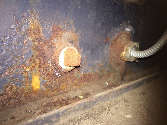 Rostig yta och propp på en panna med tecken på oxidation och potentiell strukturell degradering.