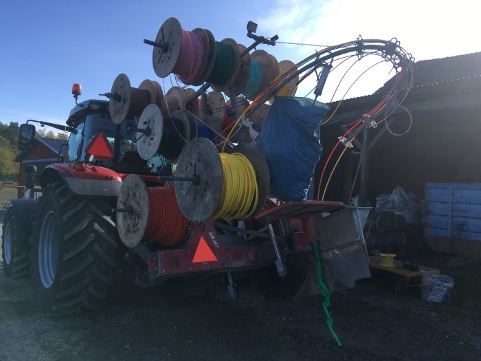 Traktor utrustad för microtrenching med flera fiberkablarullar redo för nedfräsning i vägen.