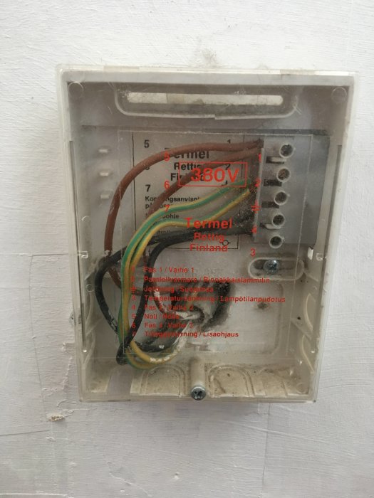 En elektrisk kopplingsdosa med flera kablar och etiketter som visar 380V, vilket tyder på en äldre installation.