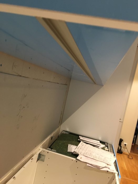 Kök under renovering med omonterade IKEA köksstommar och markerade mått på väggen.