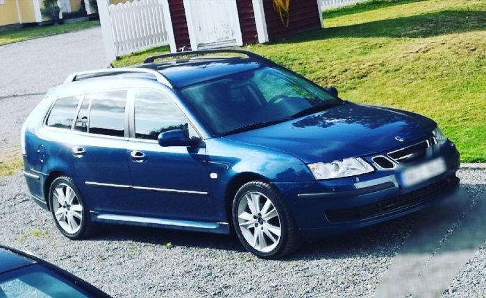 Blå SAAB 9-3 1,8t Vector 2007 parkerad framför hus med vita staket.