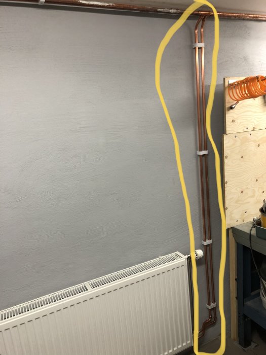 Rördragning för radiator markerat med gult område på vägg i ett rum.