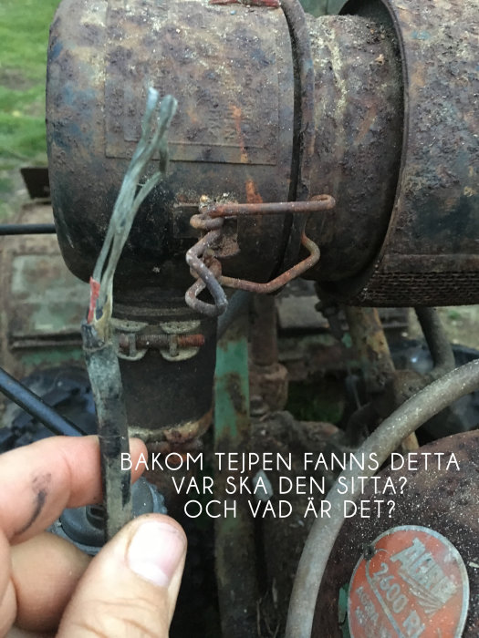 Närbild på rostig motor med okopplade kablar och osäker fastsättning, fråga om montering.