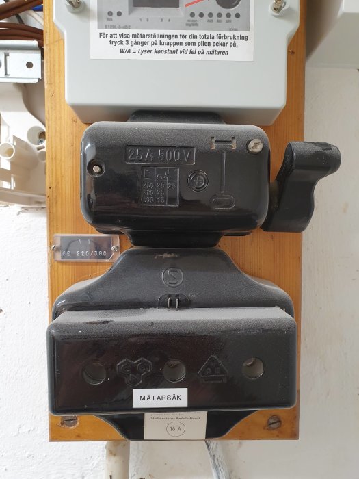 En gammal elektrisk mätarsäkring monterad på en vägg som ser industriell ut.