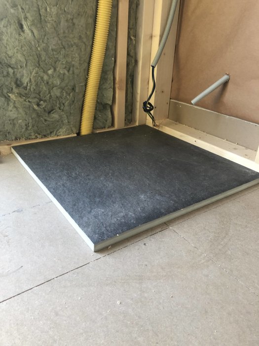 Stengolvplatta i en byggkonstruktion med isolering och elinstallationer synliga.
