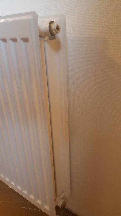 Nymonterat större element utan luftnippel mot vit vägg.