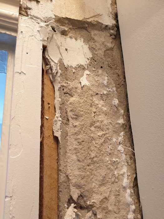 Ojämna och skadade betongytor med löst material och delvis pålagd husfix i en garderob under renovering.