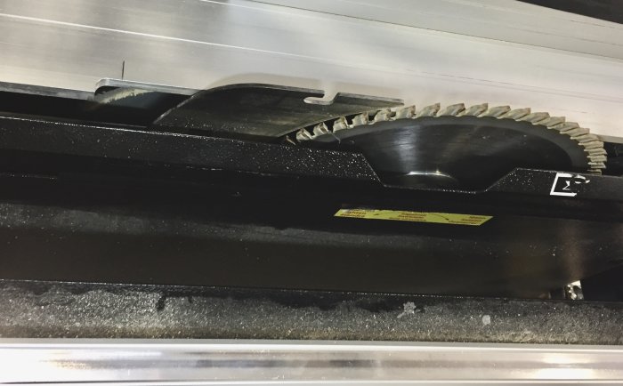 Inuti en Metabo PKF 255 V8 formatsåg med synligt sågblad och uppsamlingsutrymme för spån.