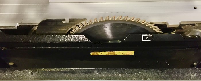 Närbild av Metabo PKF 255 V8 formatsåg med synlig sågklinga och spån i sågklingans utrymme.