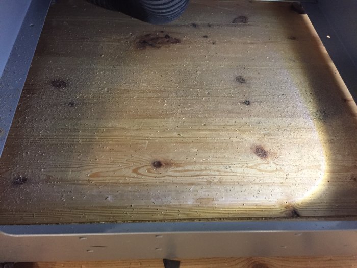 Träyta täckt med sågspån efter användning av uppgraderad formatsåg.