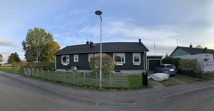 Panoramabild av en husfasad med uppfart och trädgård i behov av ombyggnad och designförslag.