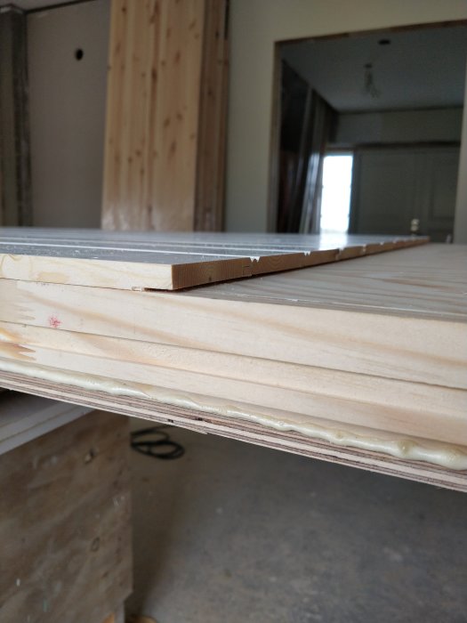 Plywood och isoleringsskikt i en dörr under tillverkning, sedd från sidan.