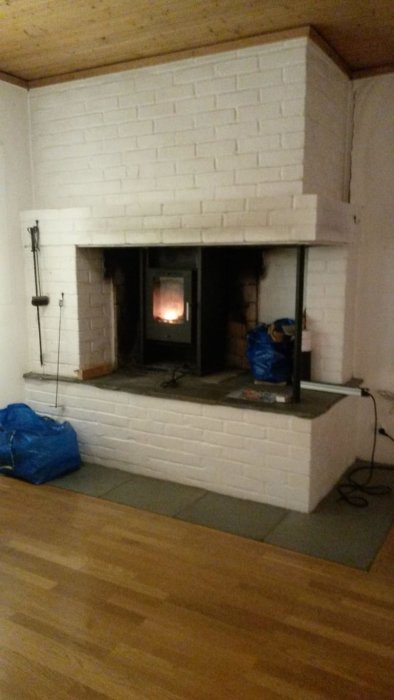 En stor murad spis med en liten brinnande eldstad i mitten av ett vardagsrum.