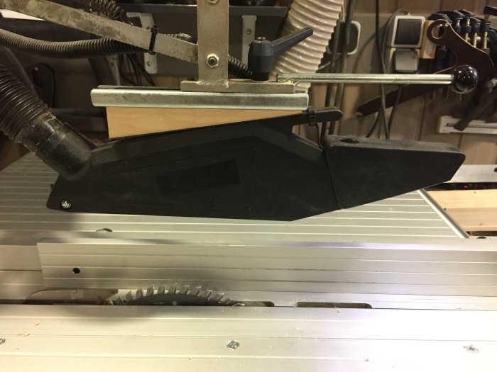 Anpassat svart sågskydd monterat över cirkelsågsklinga på en bänksåg.