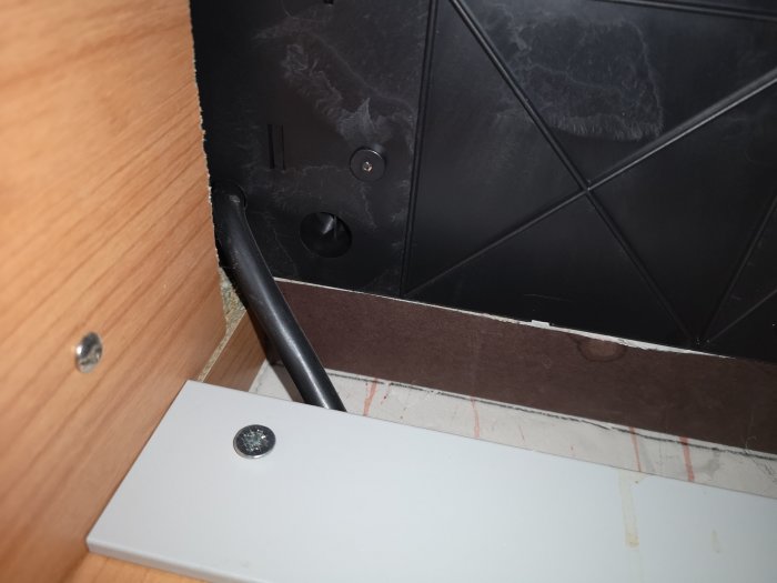 En hälls anslutningskabel som försvinner in i undersidan av hällen utan synlig kopplingsplint.
