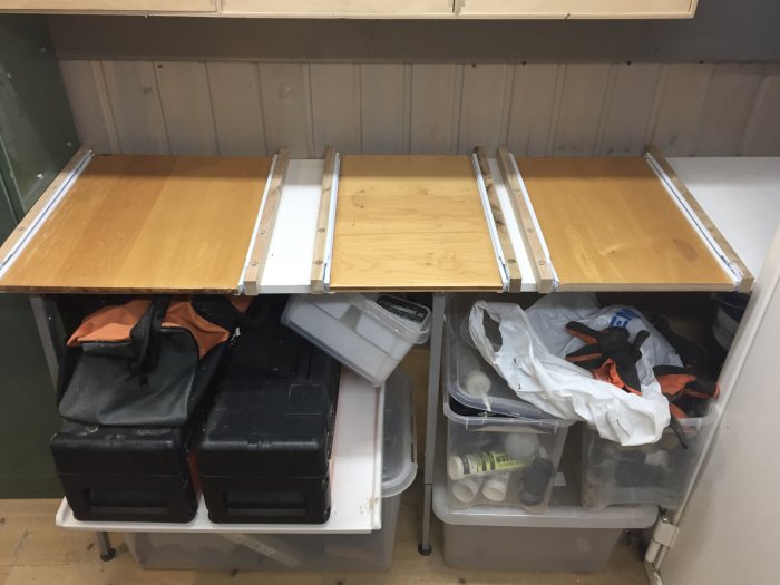 Tre återanvända köksluckor monterade som utdragbara plattor på expansionsbeslag ovanför förvaringslådor.