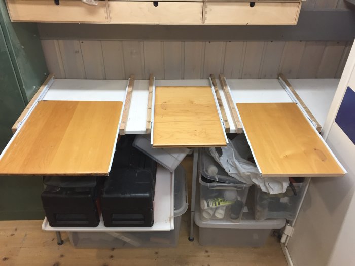 Tre återvunna köksluckor monterade som utdragbara plattor med expansionsbeslag på en arbetsbänk.