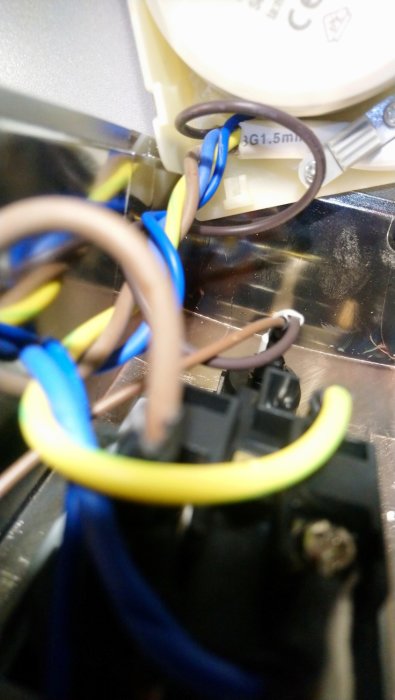 Elektriska ledningar och anslutningar inuti en apparat, inga synliga brännskador.