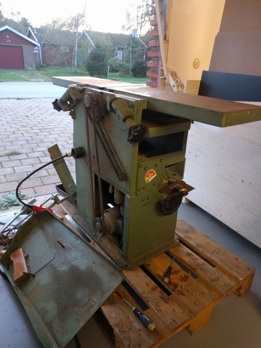 En använd Ejca plan och rikthyvel med delvis demonterade delar och eltillbehör, på en träpall.