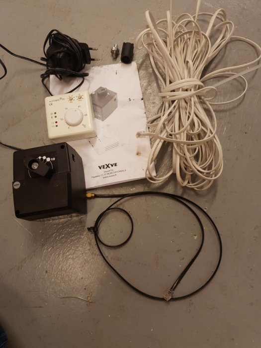 Automix 20 temperaturregleringssystem med shuntmotor, kablar, givare och nätaggregat på ett grått golv.