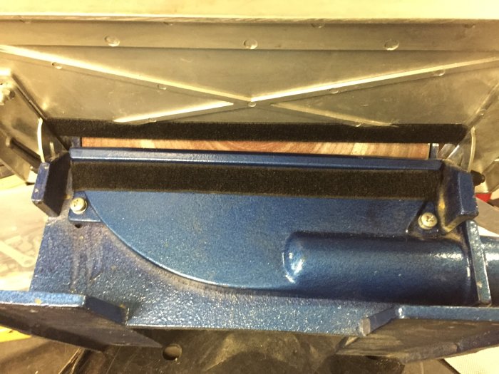 Modifikation av en slipmaskin med tätad dammutsug och borttagen slipskiva, avslutad med kardborreband.