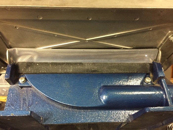 Maskin med fastskruvad och tätad gummiduk och kardborreband i ett verkstadssammanhang.