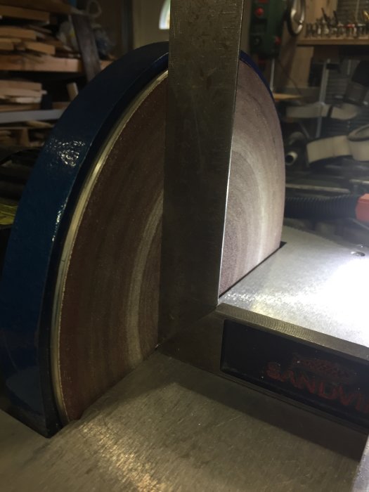 Verkstadsbild med en vertikal slipmaskin, justerad och anpassad för optimal dammutsugning.