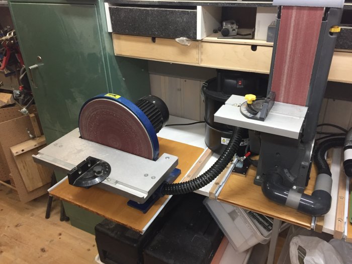 Verkstadsutrustning med slipmaskiner, sugrör och kardborreband på en arbetsbänk, fastskruvat och tätat.