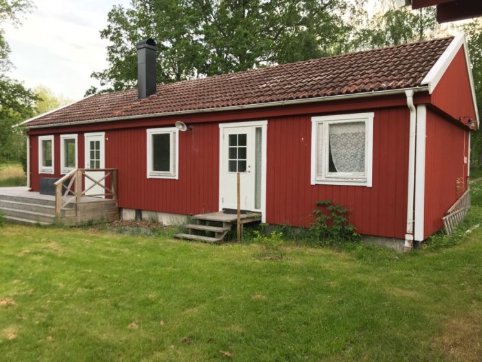 Röd stuga med betongpannetak från 1971 och lutning på 27 grader som ska läggas om.