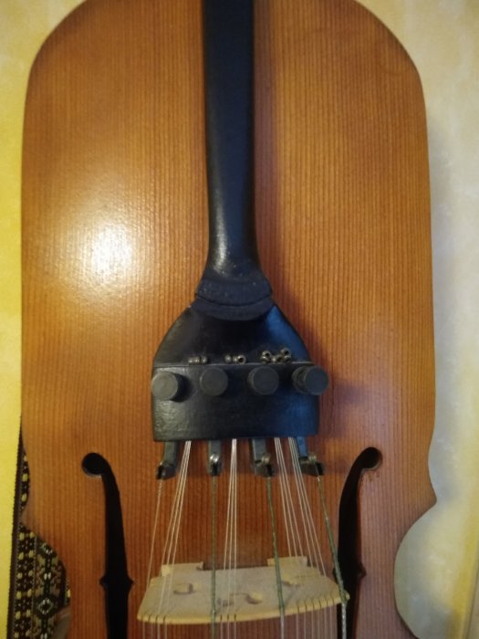 Ett granvirke behandlat med mörk Herdins lackbets, del av en nyckelharpa mot en träbakgrund.