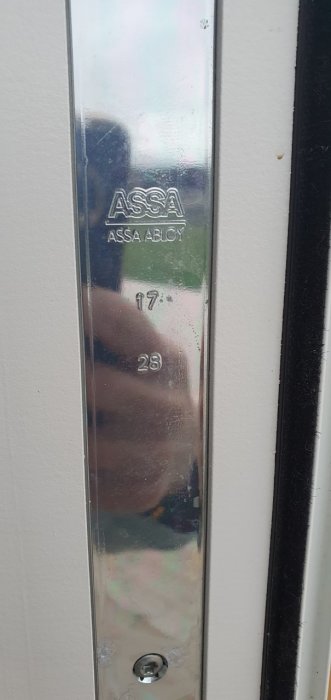Altandörrs låsmekanism utan handtag med ASSA ABLOY-logotyp och skruvhål.
