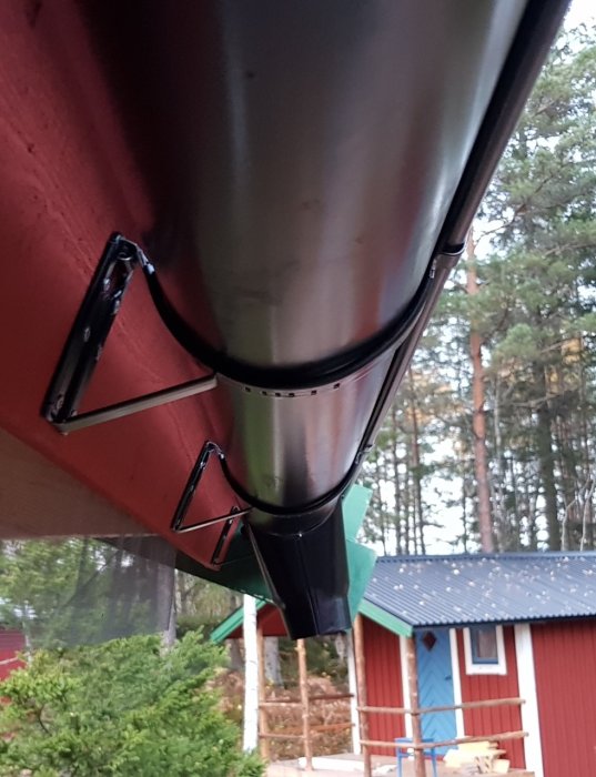 Hängränna med felriktad utloppskupa som pekar utåt på ett rött hus, med fråga om felande delar.