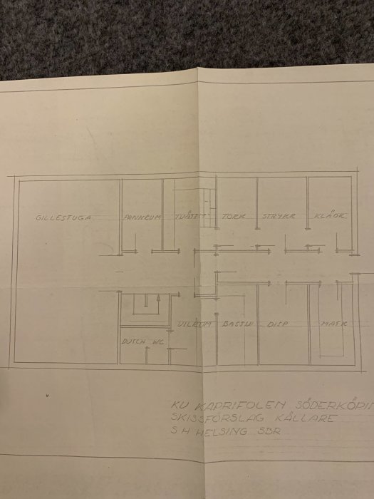 Handritad skiss över källarplan med betecknade rum som gillestuga, pannrum och tvättstuga.