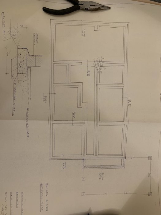 Arkitektritning av en källarplan med markerad bärande vägg mellan vilrum och hall.