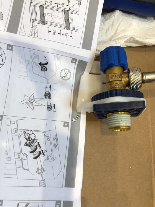 Rörkoppling och stödhylsa bredvid en instruktionsmanual för toalettinstallation.